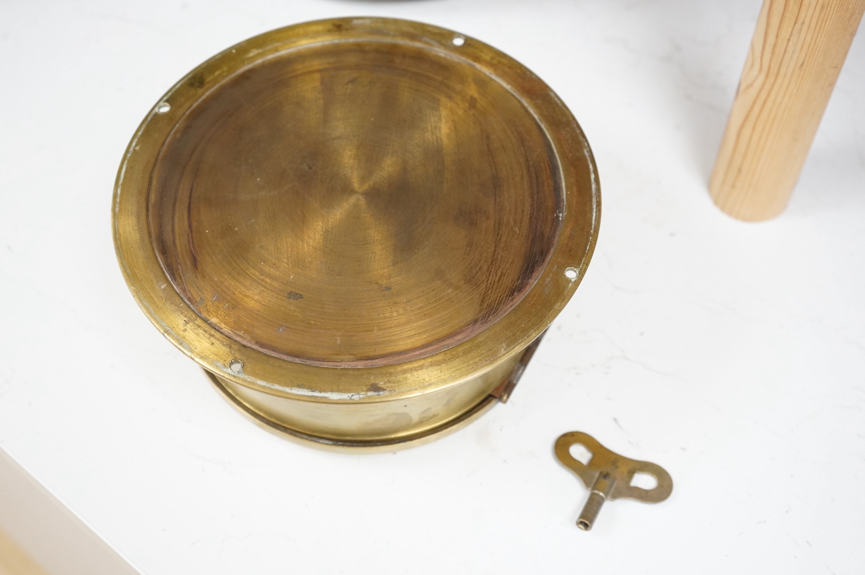 A brass ship's bulkhead timepiece, with key, 21cm in diameter. Condition - good, untested